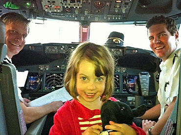 Black Dog Ride Mascot Winston visits the cockpit of a jumbo with his young friend